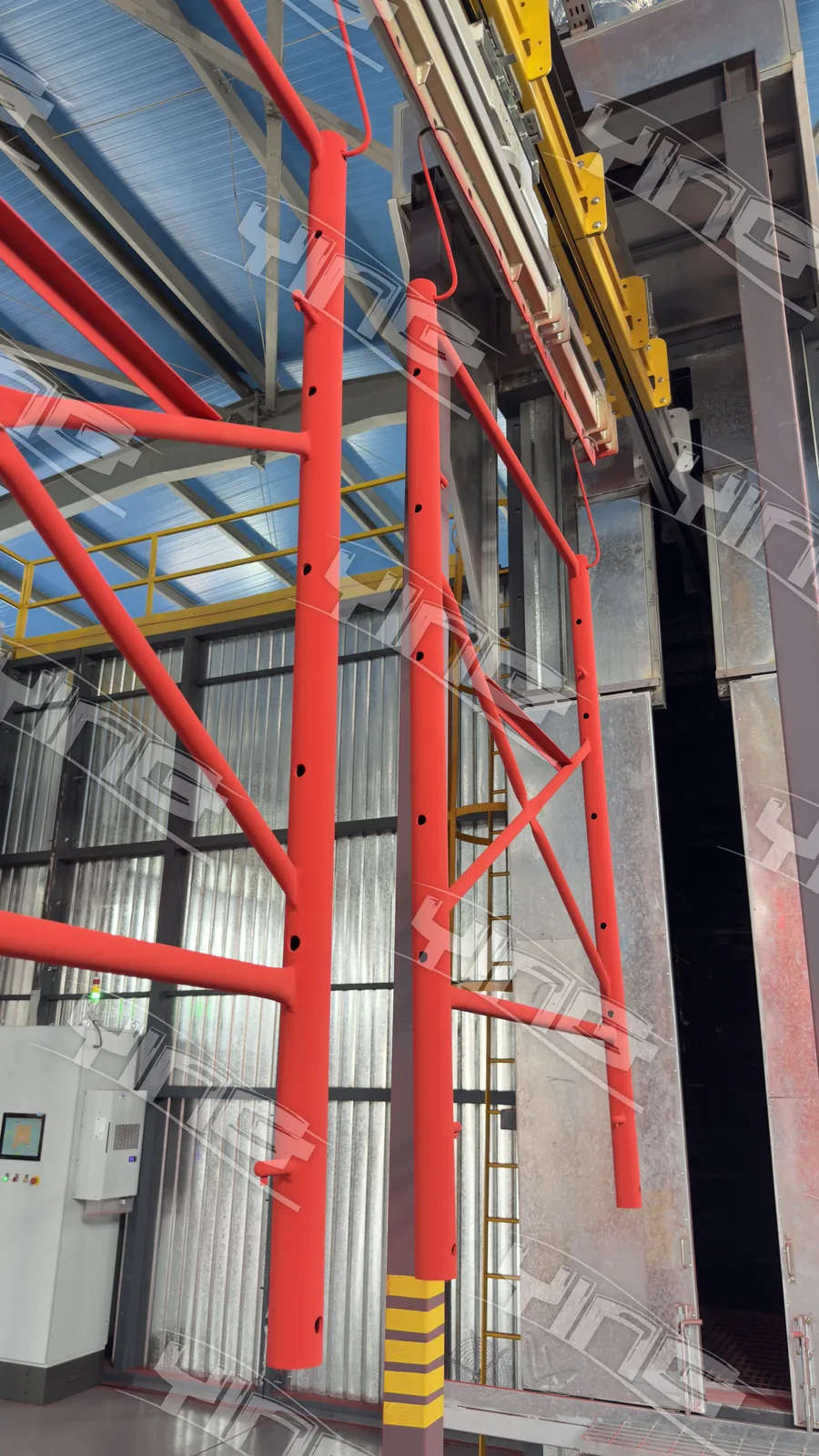 Freshly coated red frames leaving the powder booth on the conveyor