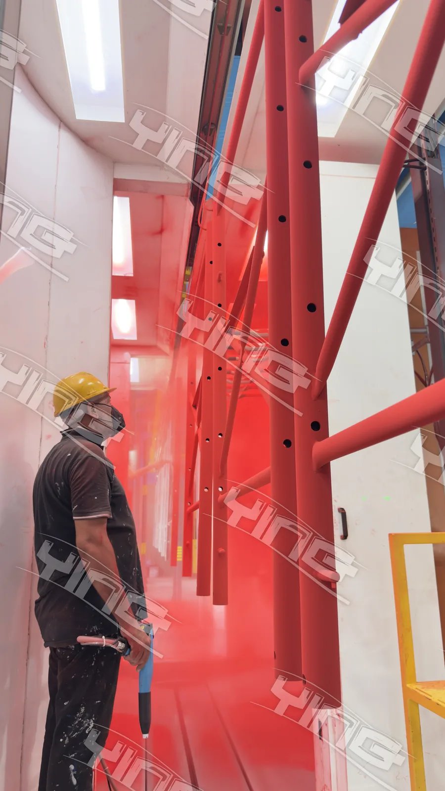 Scaffolding frames hanging in the powder booth during red powder application