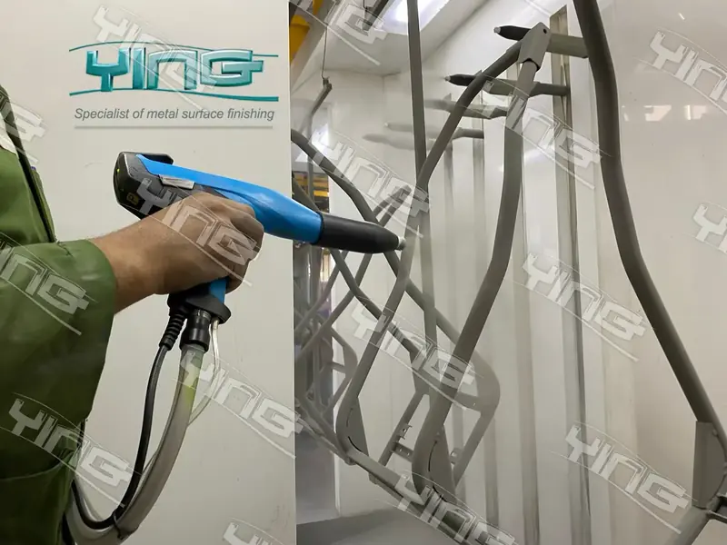 Operator applying powder coating with a spray gun