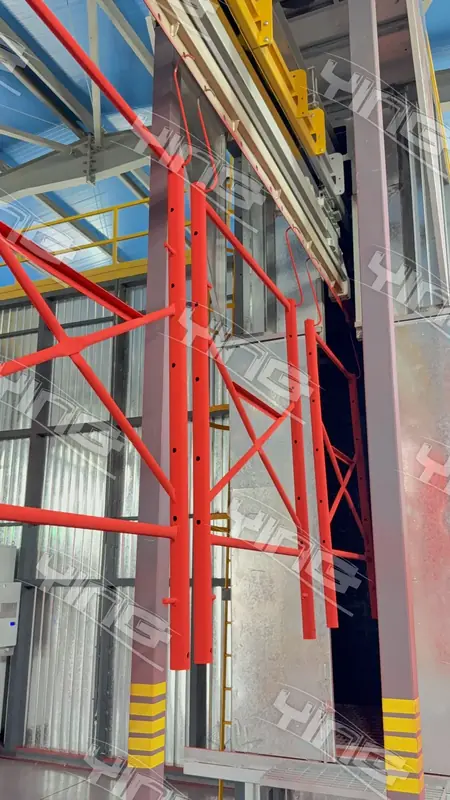 Red powder-coated steel frames hanging from the overhead conveyor of a vertical coating line